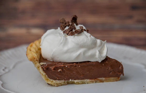 A slice of chocolate cream pie with whipped cream